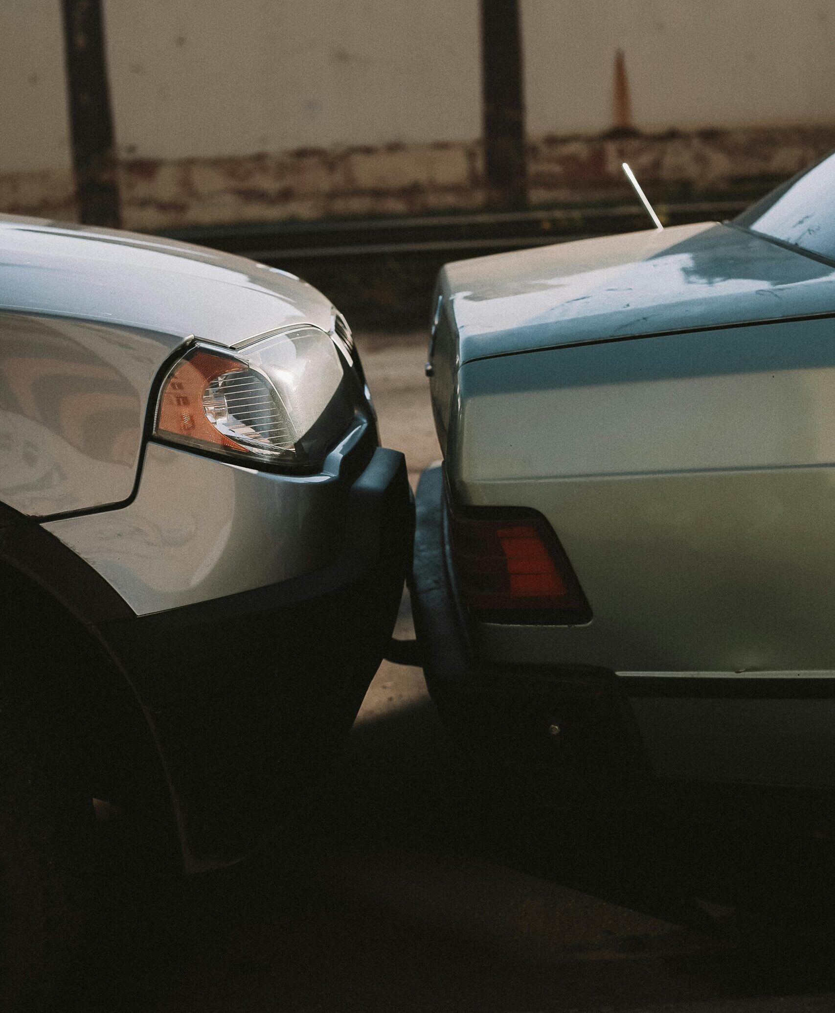 A close-up view showing the aftermath of a rear-end car collision in an outdoor setting.